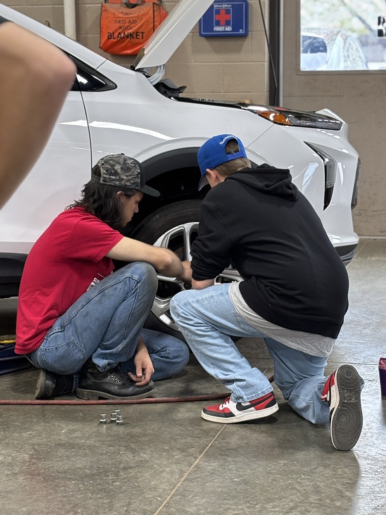 Two students working together to change a tire