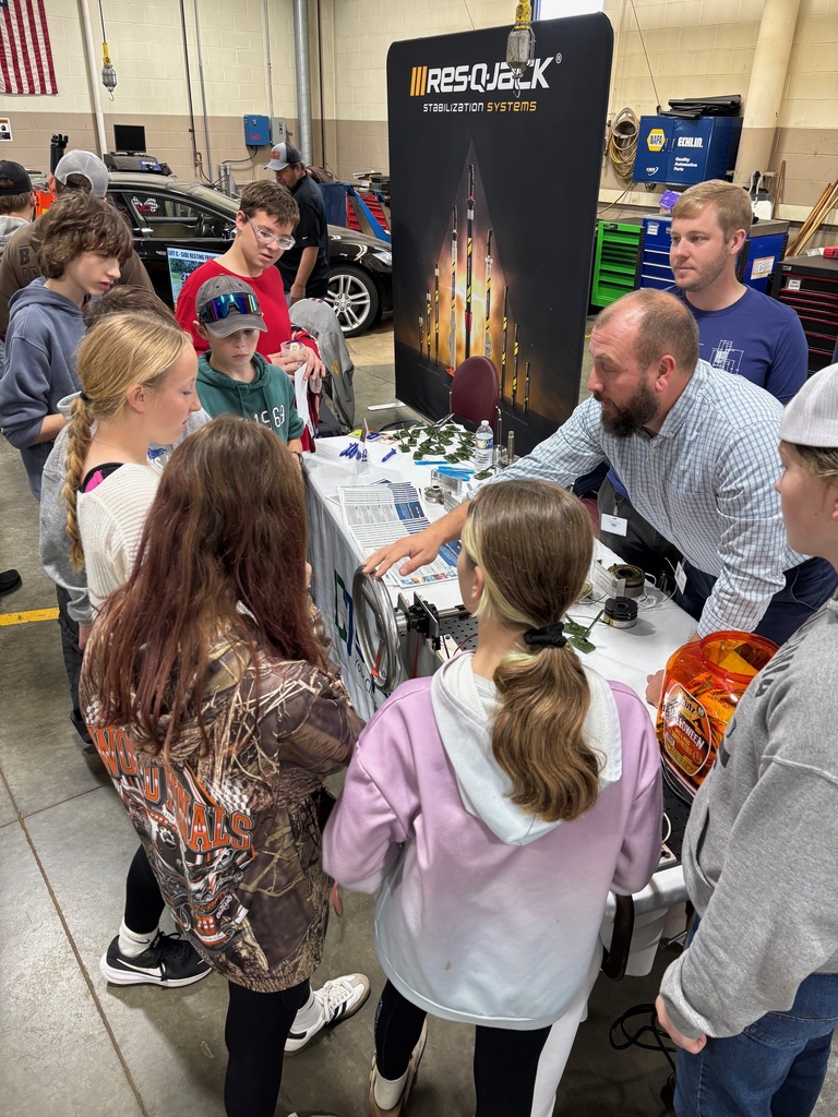 Students standing around a table for a demonstration at manufacturing day