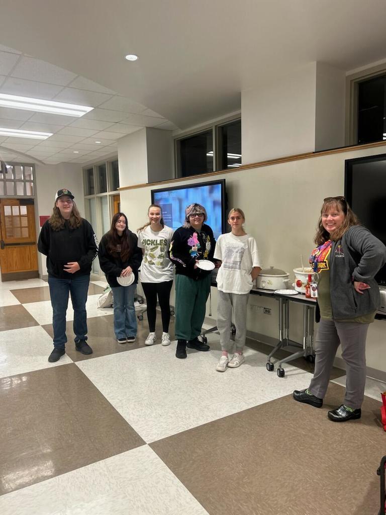 5 students posing with teacher with paper plates