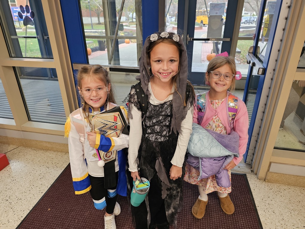 3 elementary students dressed up for halloween smiling