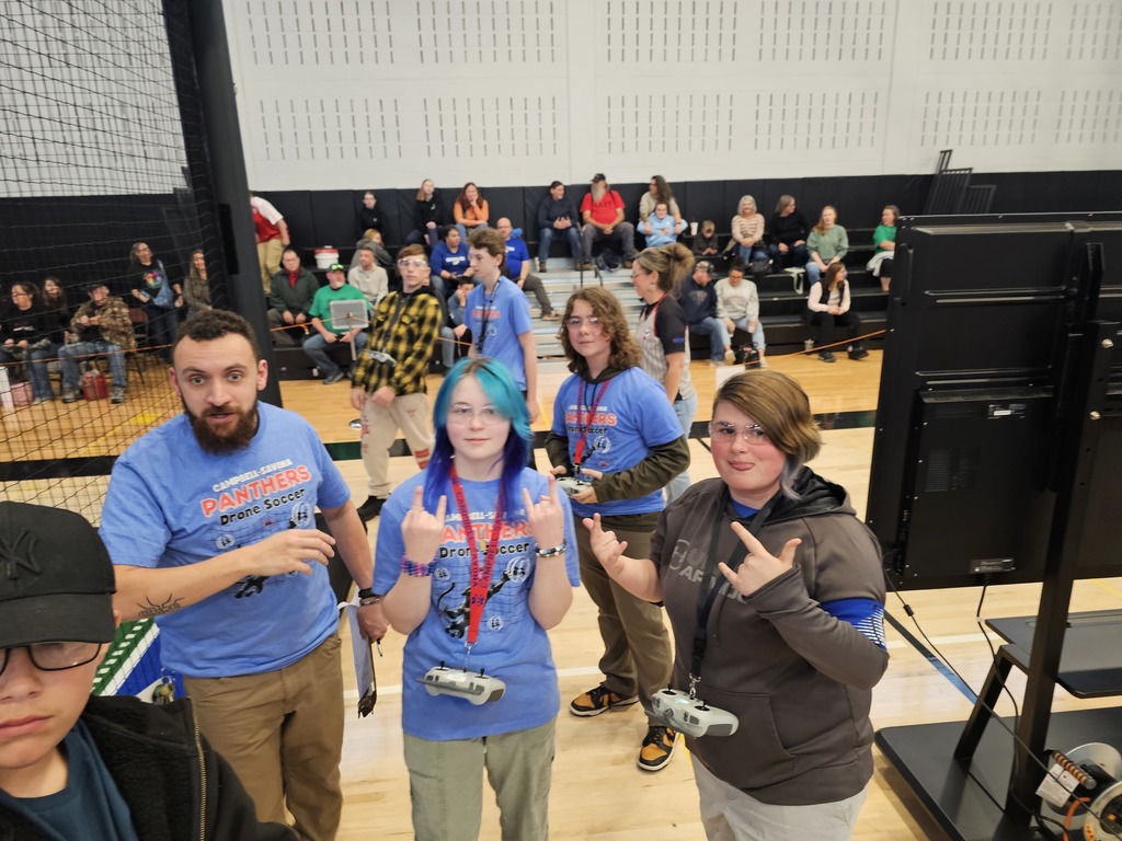 Drone soccer players with the coach posing for picture with fun hand signs