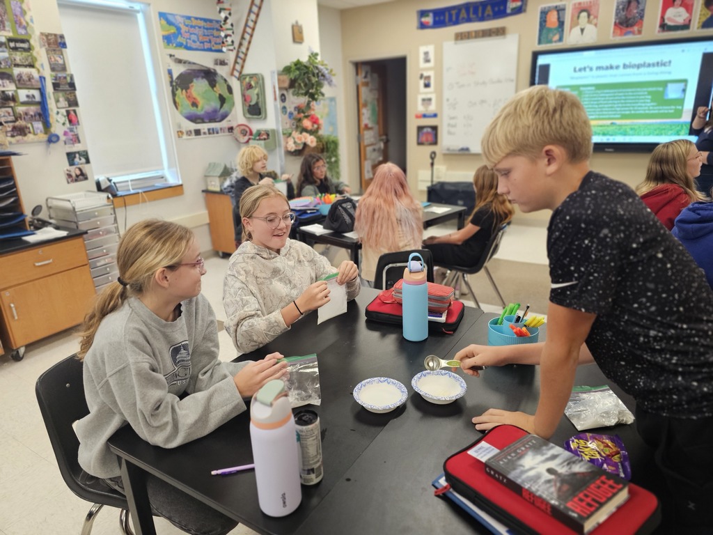 Students at table working together with baggies to make bioplastic