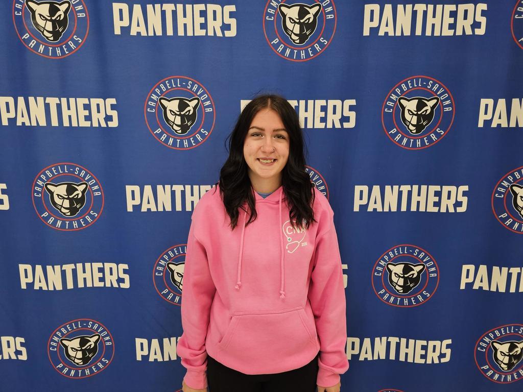 Student in pink sweatshirt standing in front of Panthers background