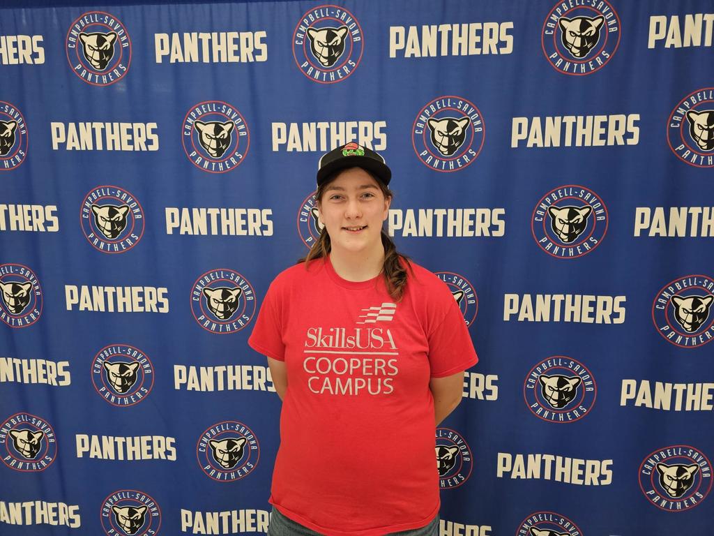 Student in red t-shirt standing in front of Panthers background