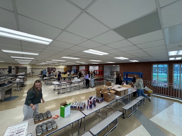 People in the cafeteria making bags of food