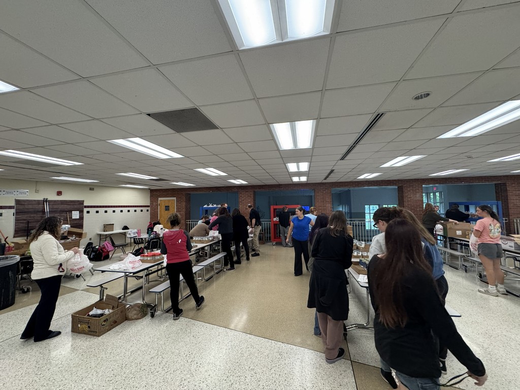 People in the cafeteria making bags of food