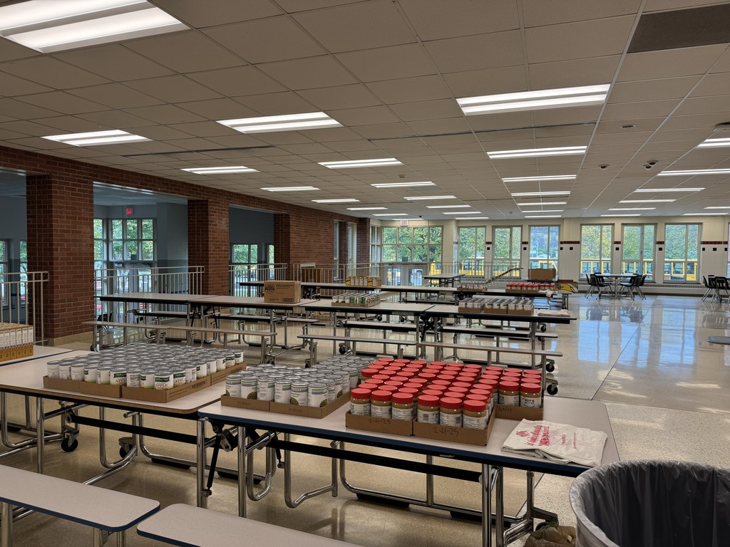 People in the cafeteria making bags of food