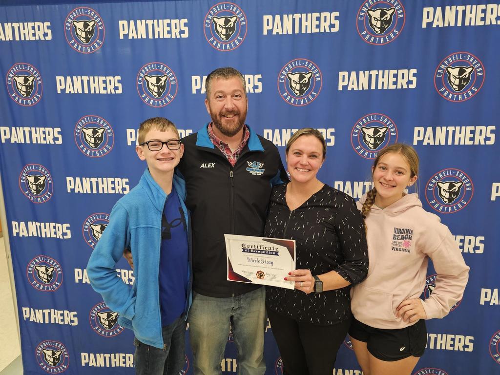 Family photo in front of School banner for certificate of recognition of Panther Pride