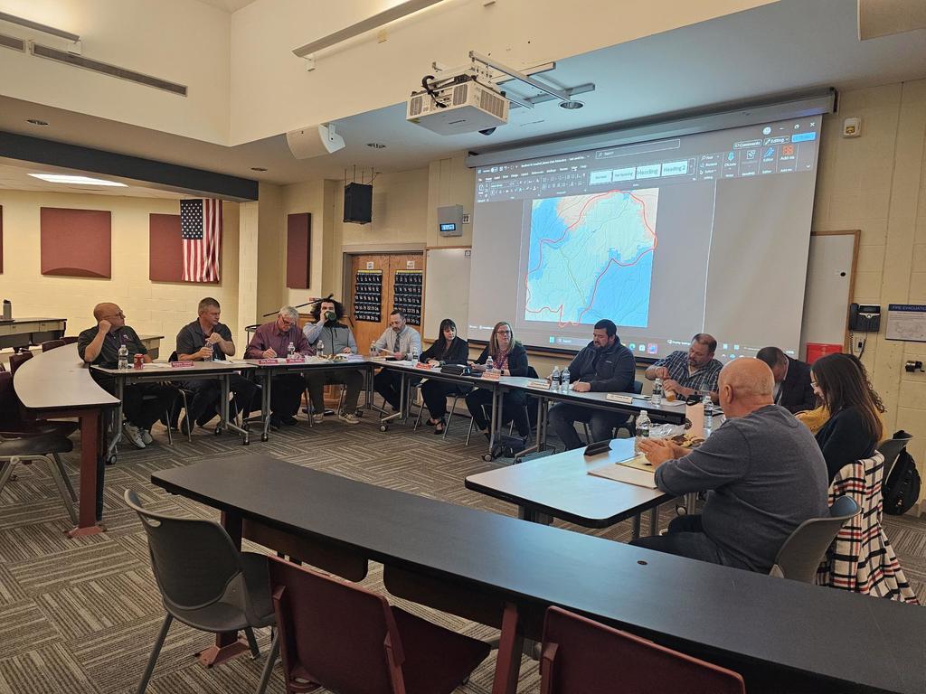 Two boards of education sitting in a U formation 