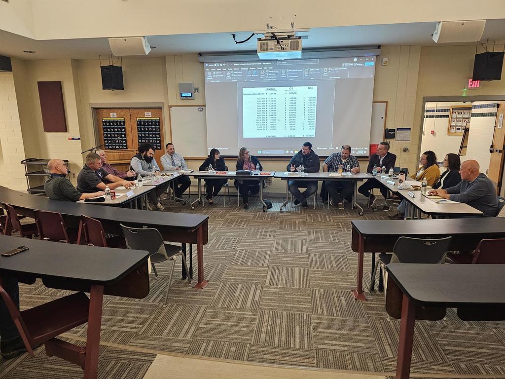 Two boards of education sitting in a U formation 