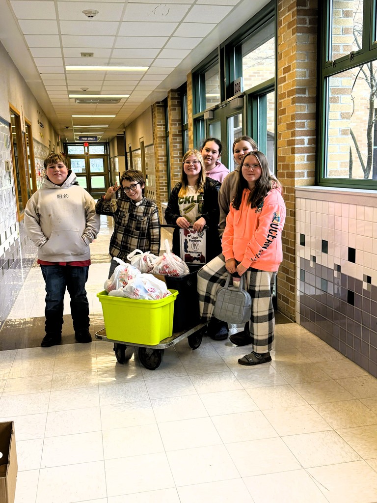 6 students posing in front of cart with back back program bags.