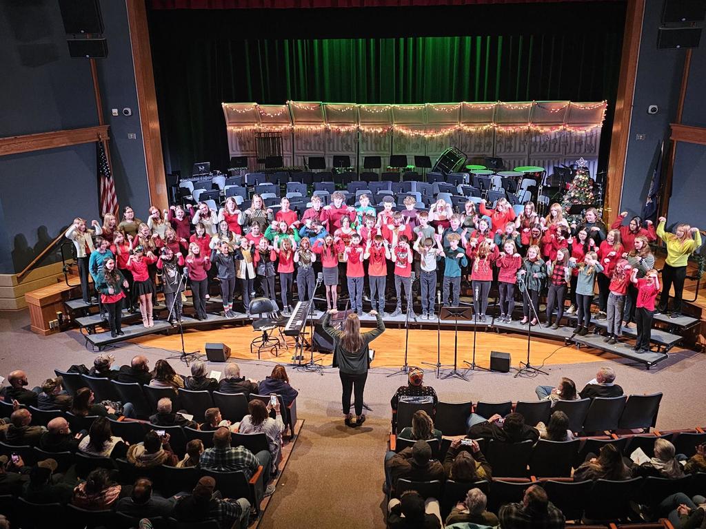 Picture of the entire junior high chorus on the risers performing