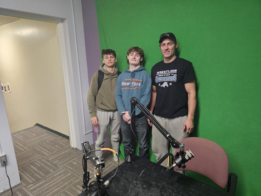 Wrestling coach and two wrestlers posing for picture
