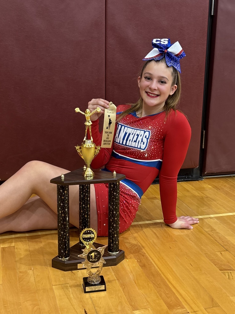 Cheerleader ith medal and trophy posing