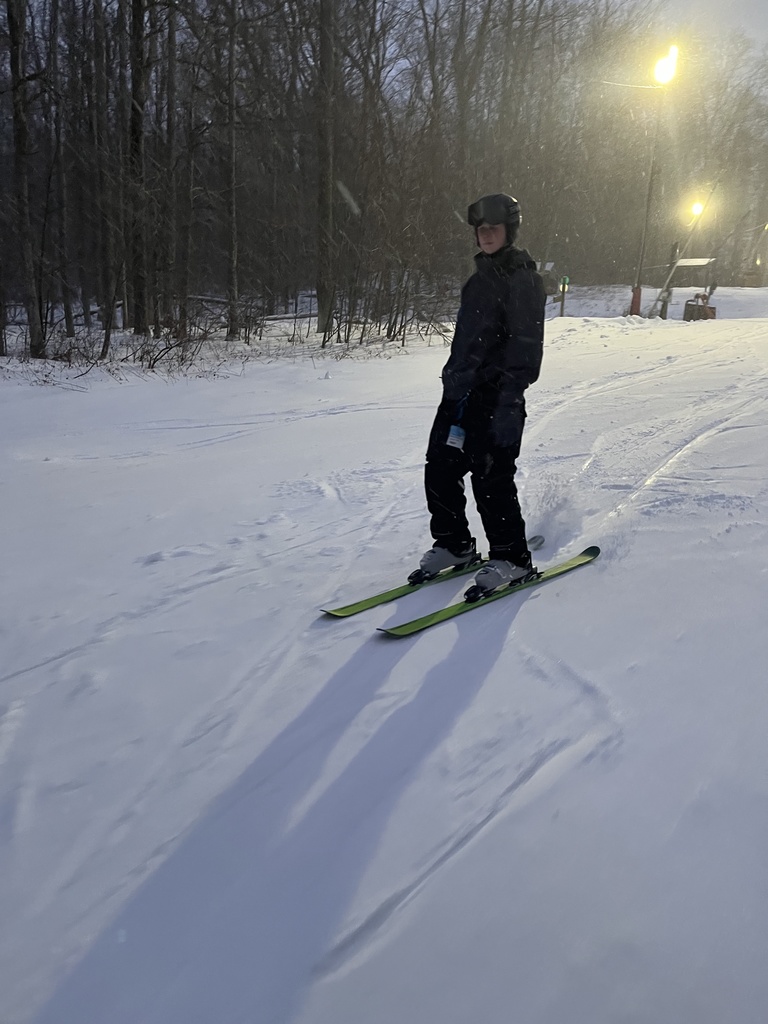 Student standing on ski's going down hill