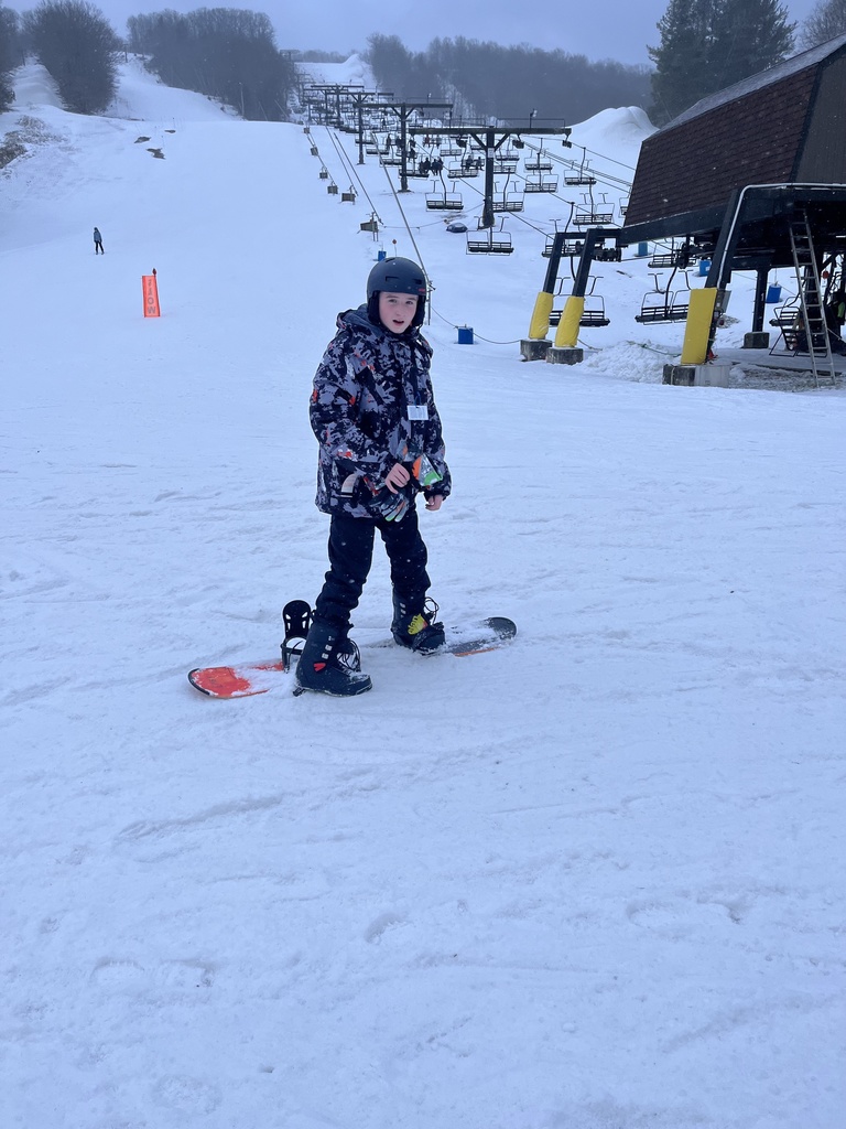 Student standing on his snow board in the snow