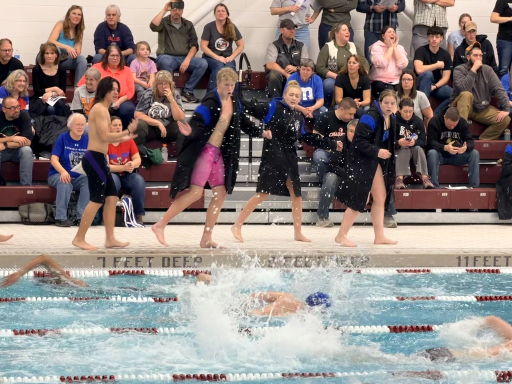 Swim team cheering on teammateas as they swim