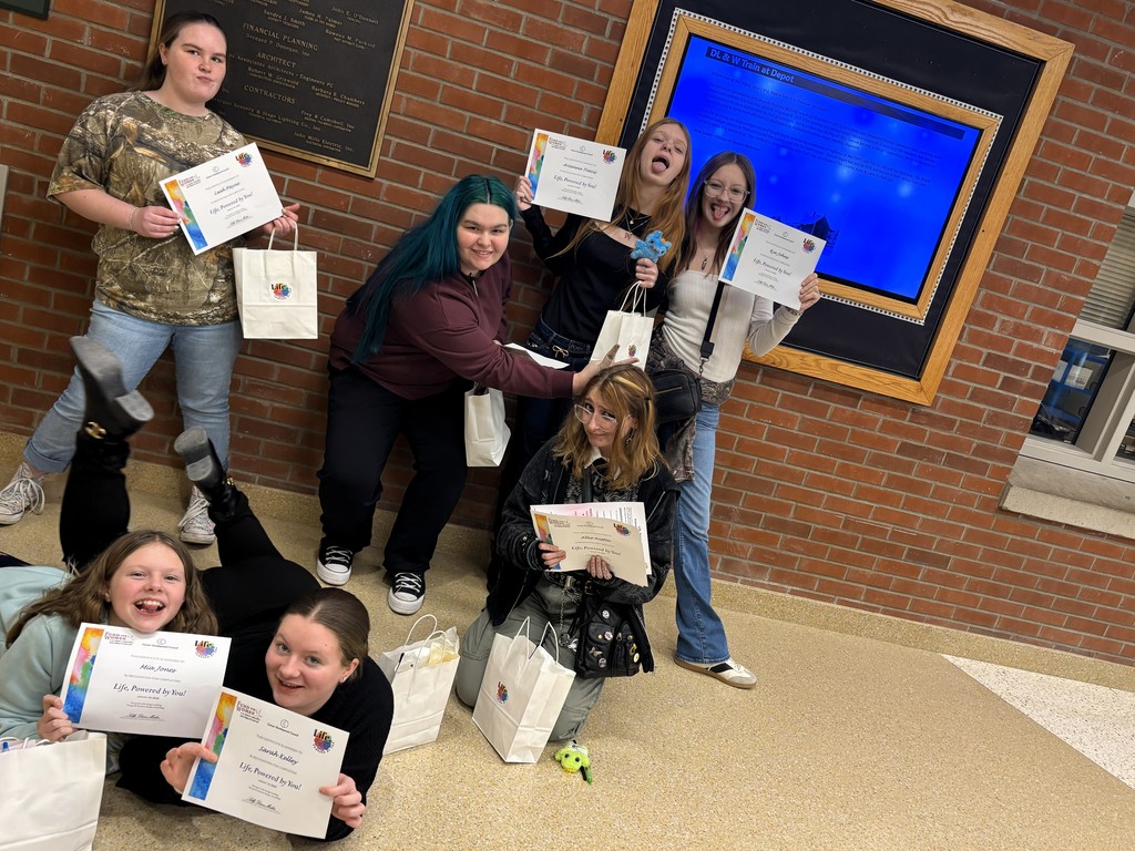 Students posing with certificates smiling and being goofy