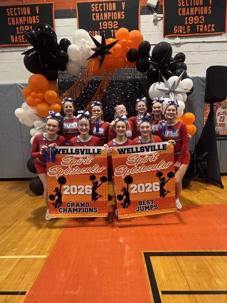 Cheer team posing for photos holding winning banners from the Wellsville competition