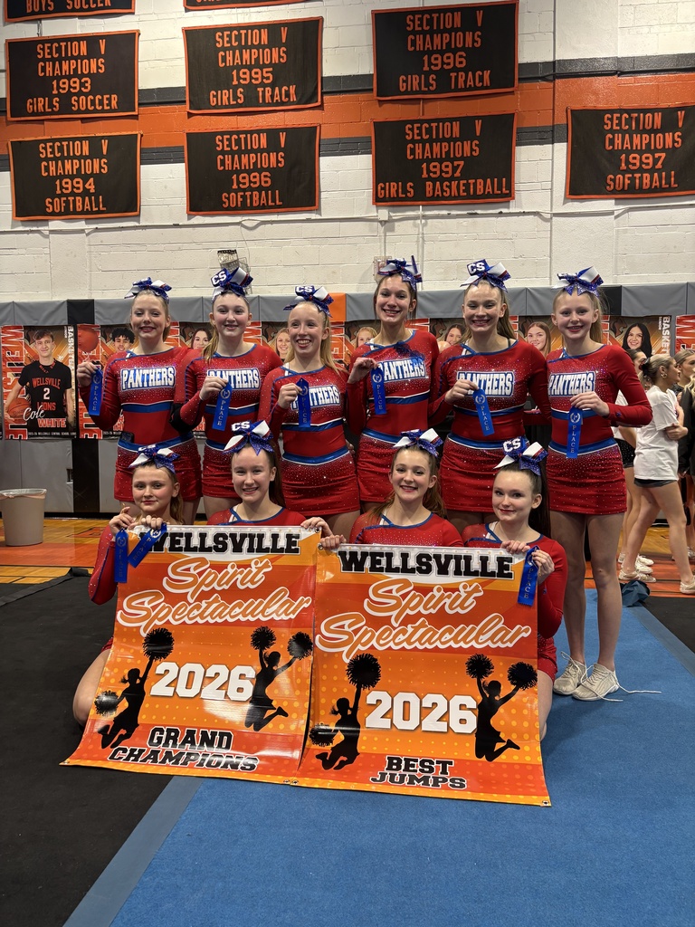 Cheer team posing for photos holding winning banners from the Wellsville competition