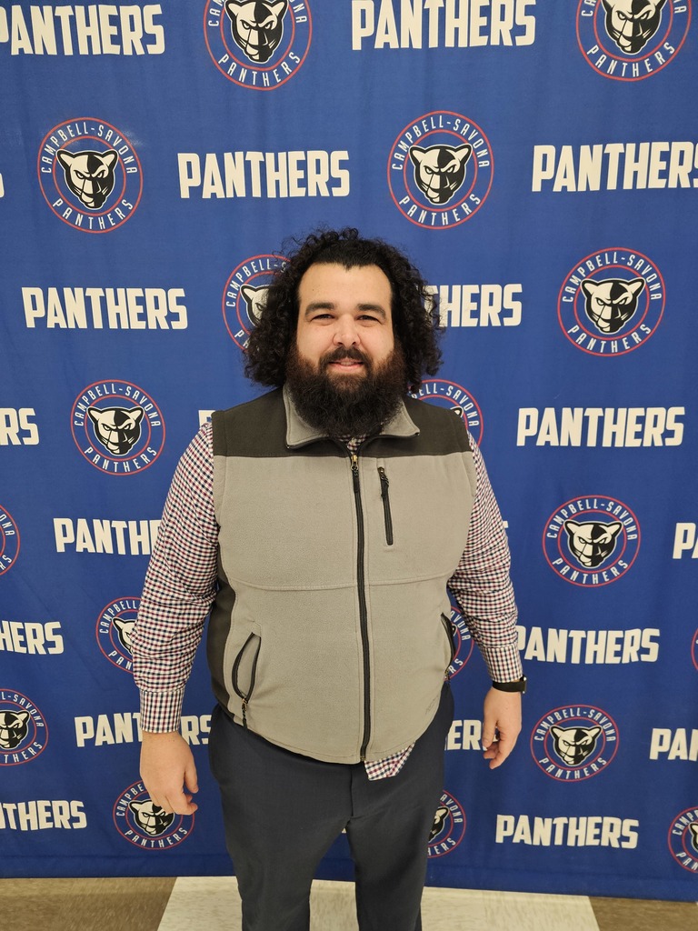 Man standing in fron of the CS Panther Banner with beard and shoulder length hair