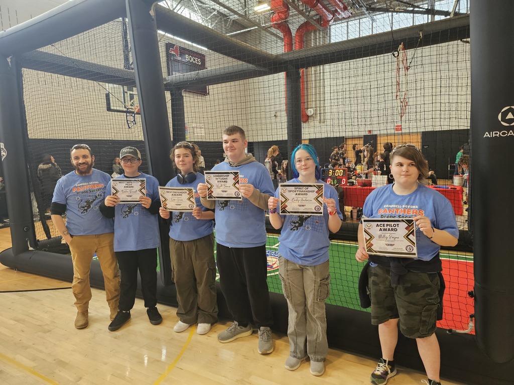 Students standing with coach with certificates of achievement