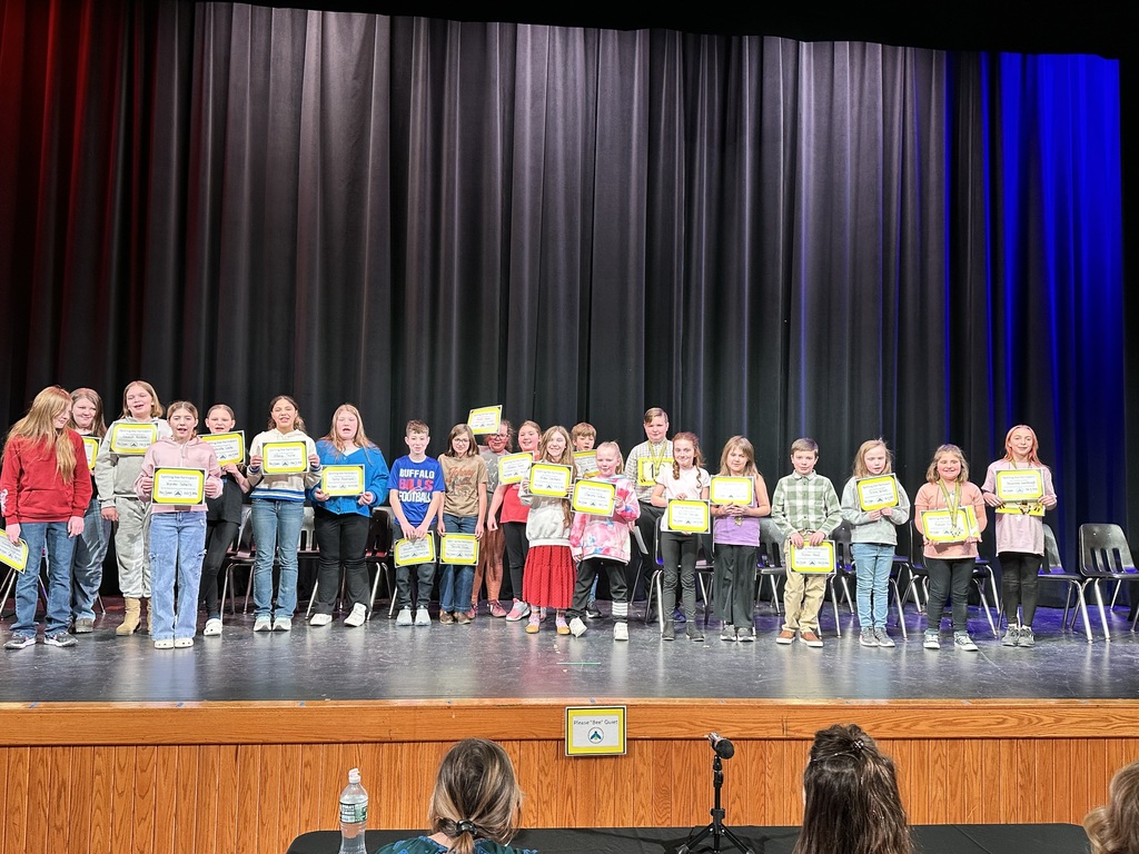 Whole group of students who particpated in the spelling bee standing on stage