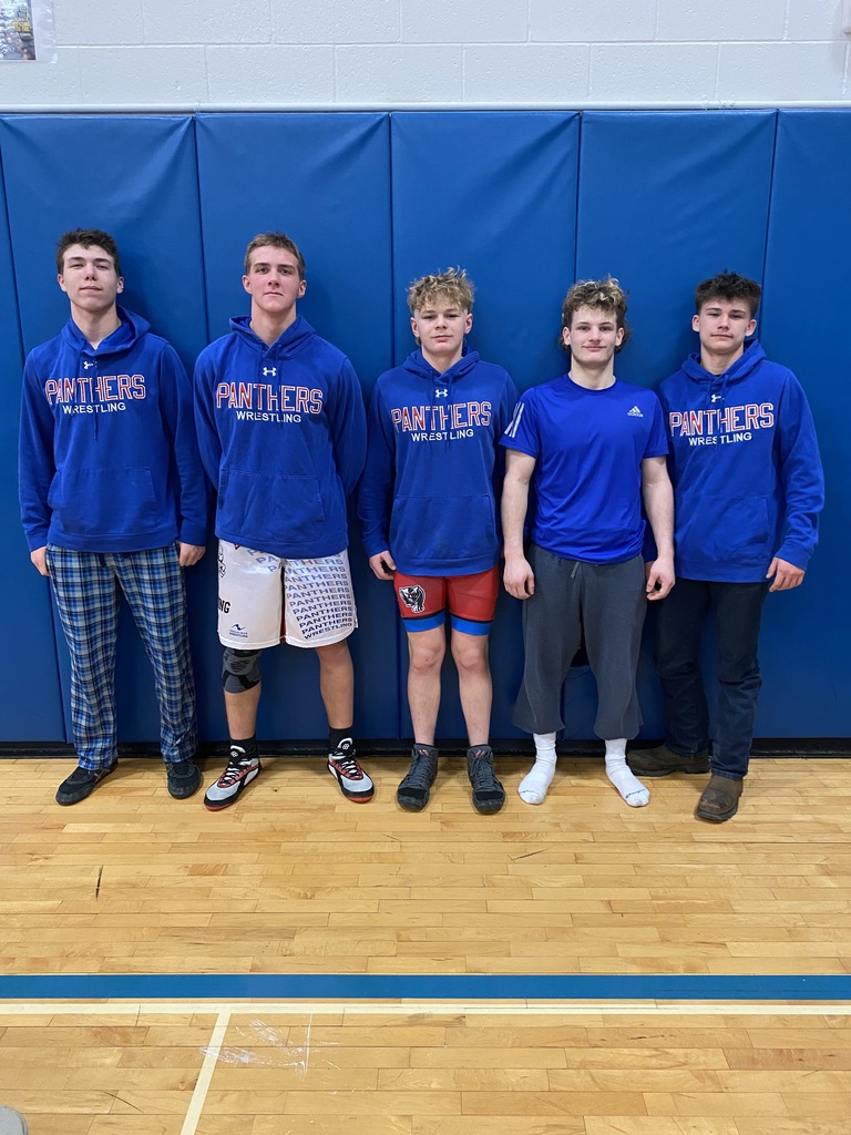 five wrestlers posing wearing blue panther gear