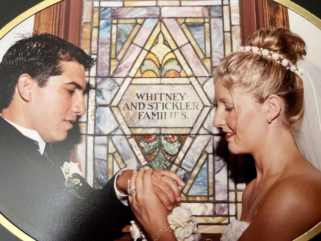 Picture of couple getting married in front of stained glass window