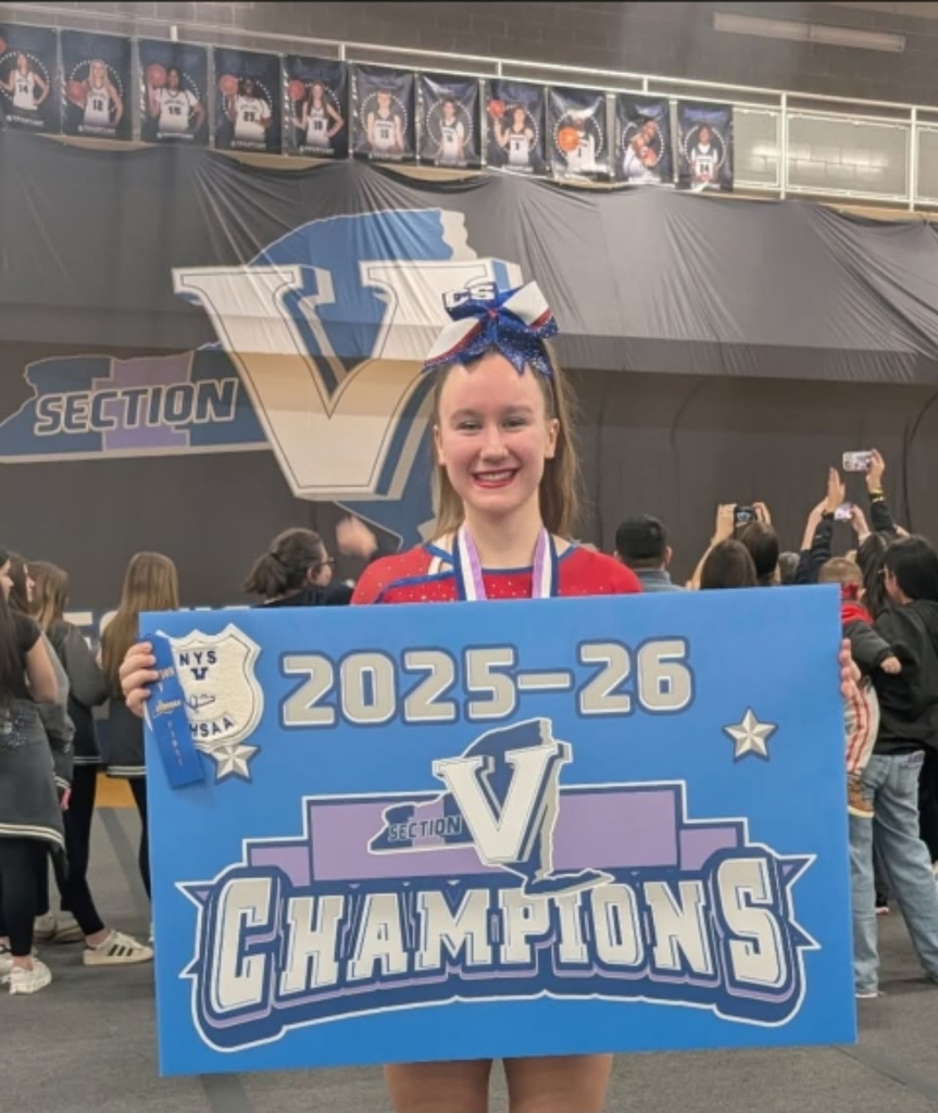 Student posing with Section 5 banner for cheer championship