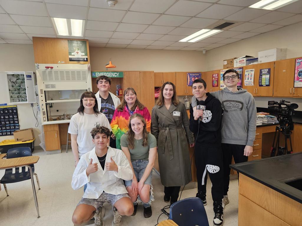 Group photo of students with her teacher and a wetm news reporter