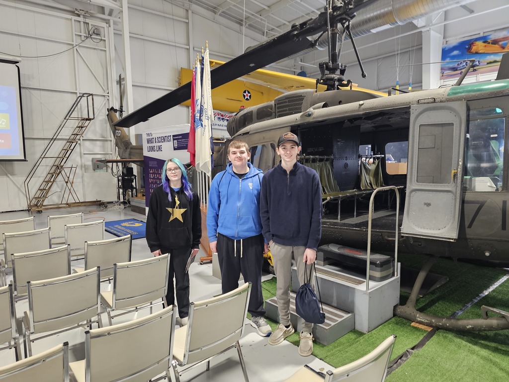 Students at wings of eagles standing in front of a helicopter