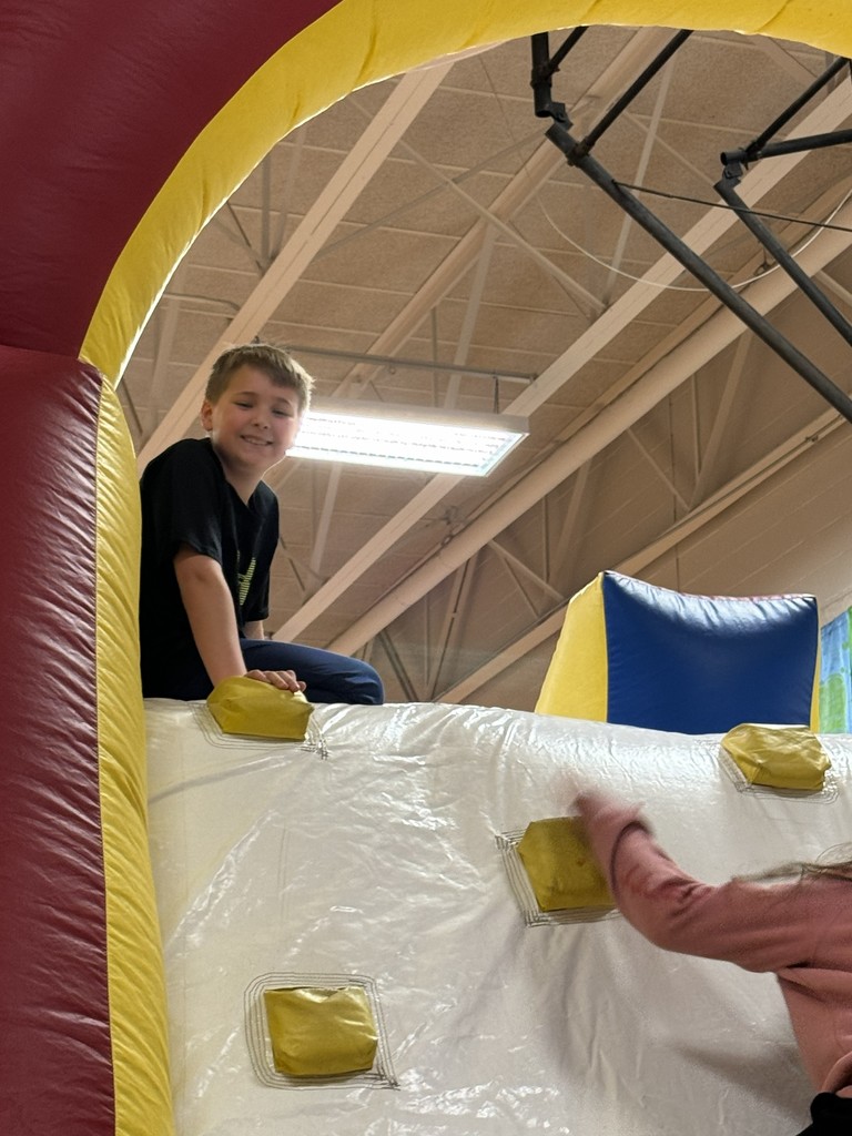 Students on the top of a large blow up slide