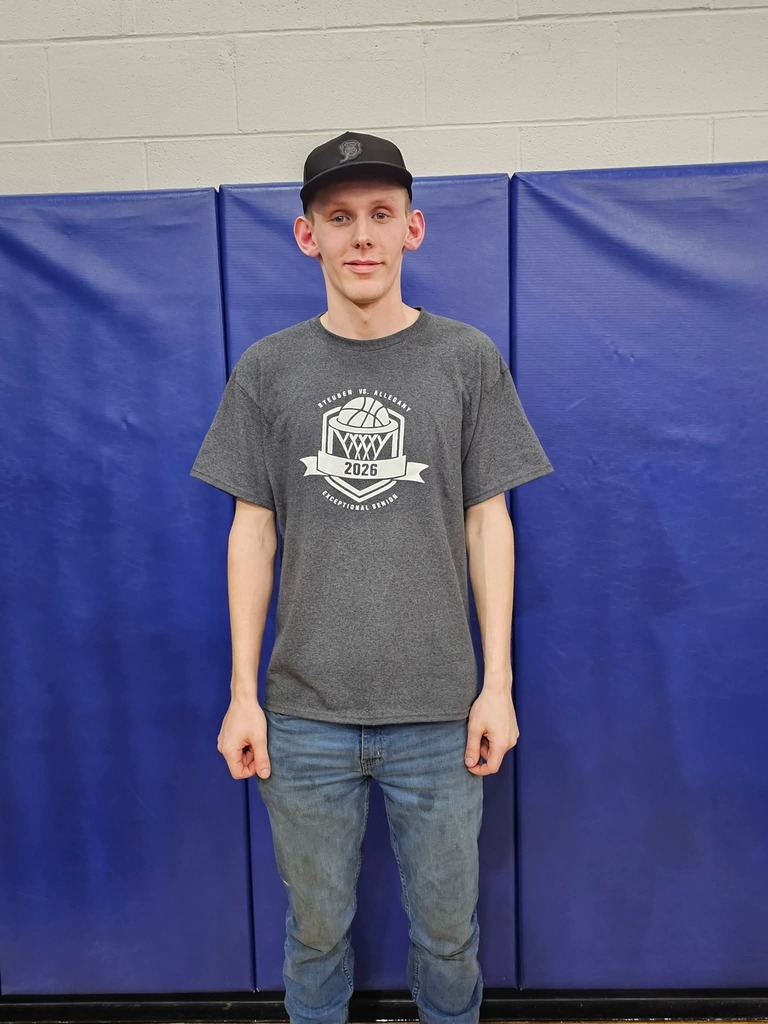 Picture of student in front of blue matts wearing gray 2026 exceptional senior shirt