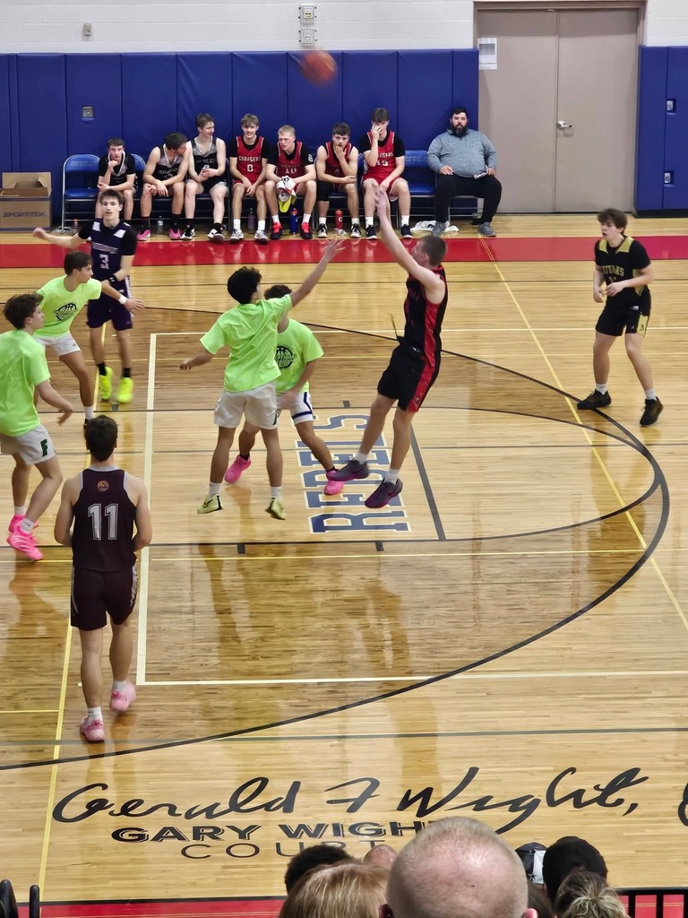 Action shot of students playing basketball one shotting from the foul line
