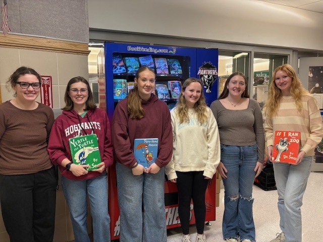 Group of NHS students holding books in the elementary school