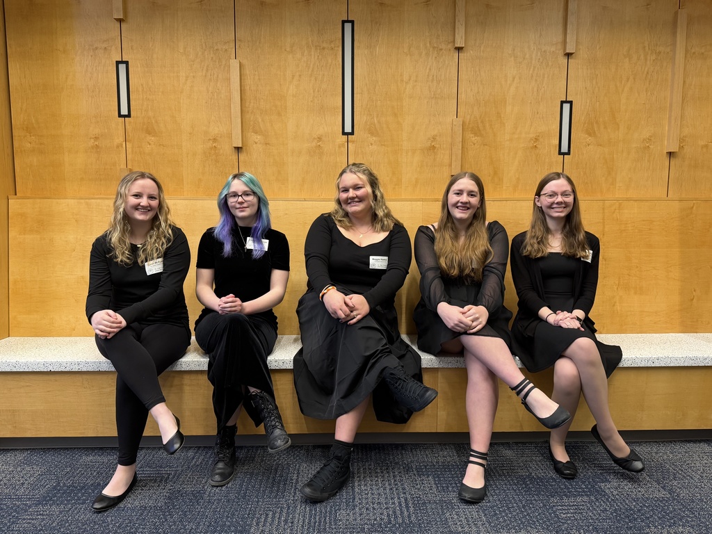 HS Chorus Dressed in black sitting smiling for picture