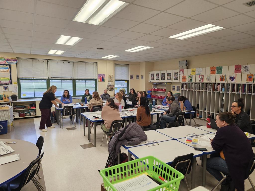 Classroom of teachers looking at presenters with computers