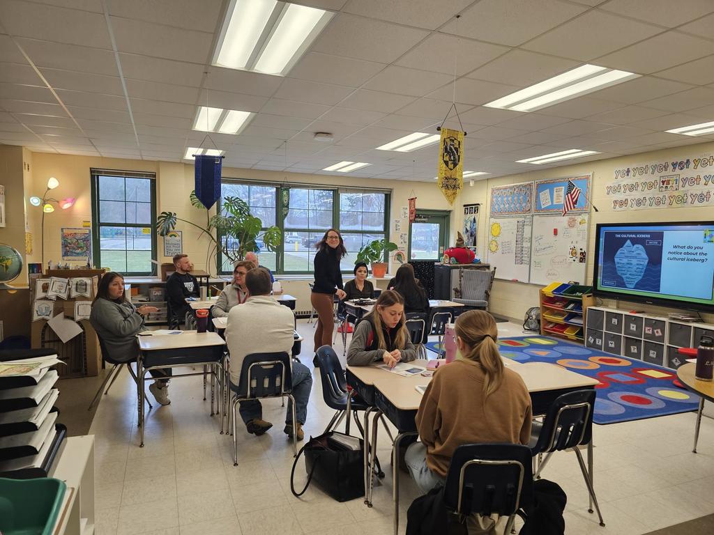 Classroom of teachers looking at presenters with computers