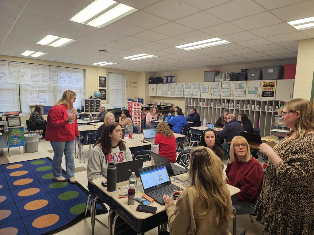 Classroom of teachers looking at presenters with computers
