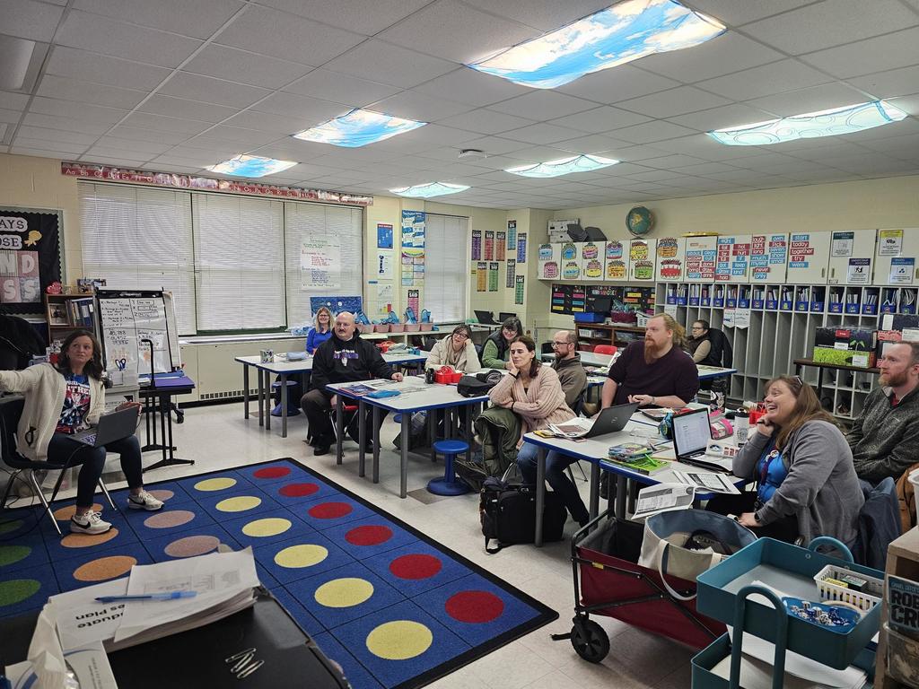 Classroom of teachers looking at presenters with computers