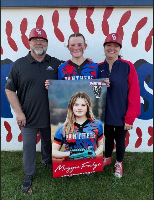 Group photo of student with coaches wearing Softball uniform