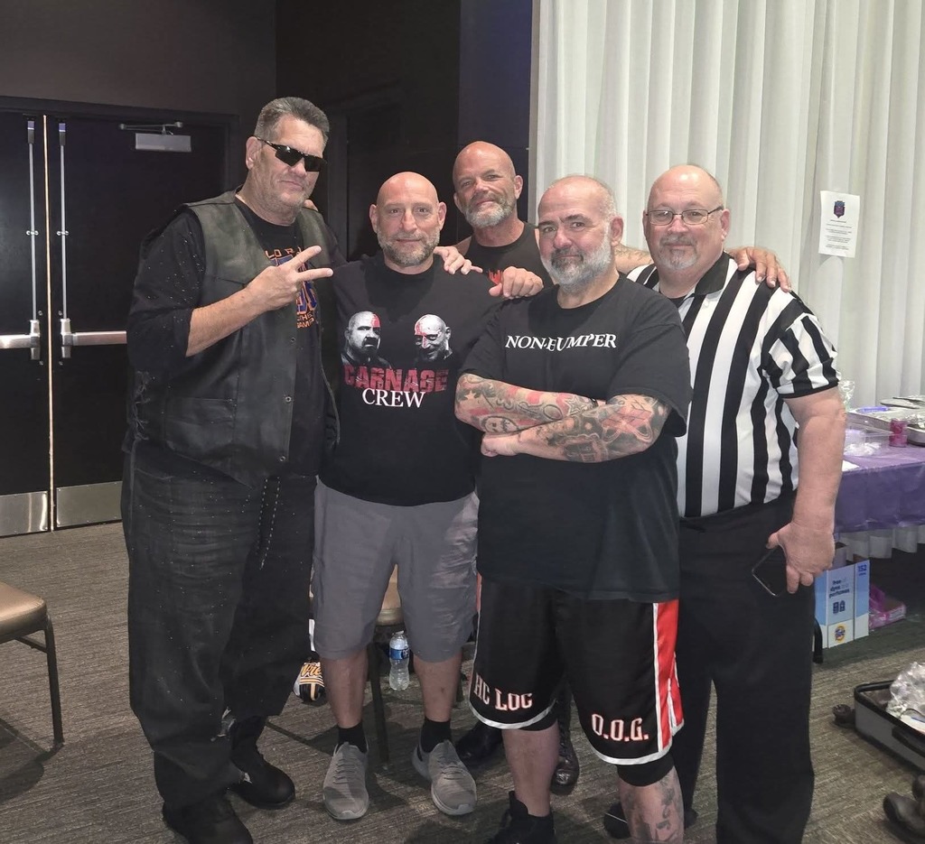Group of wrestlers standing together with a referree