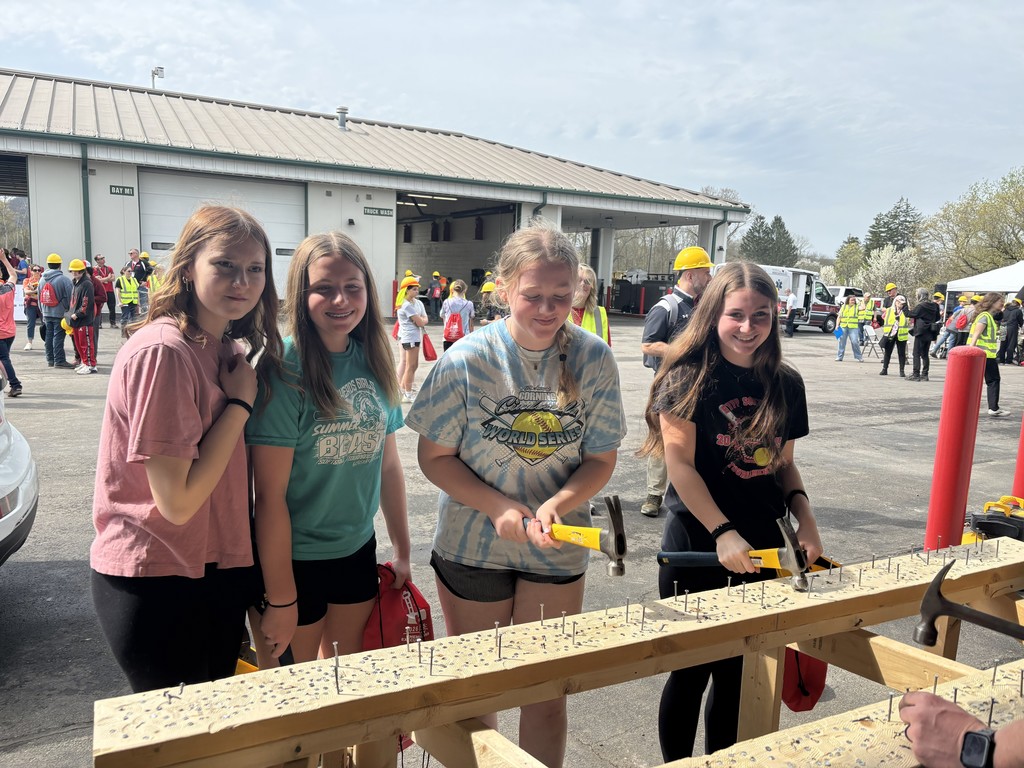 Students hitting nails with hammer.  4 students