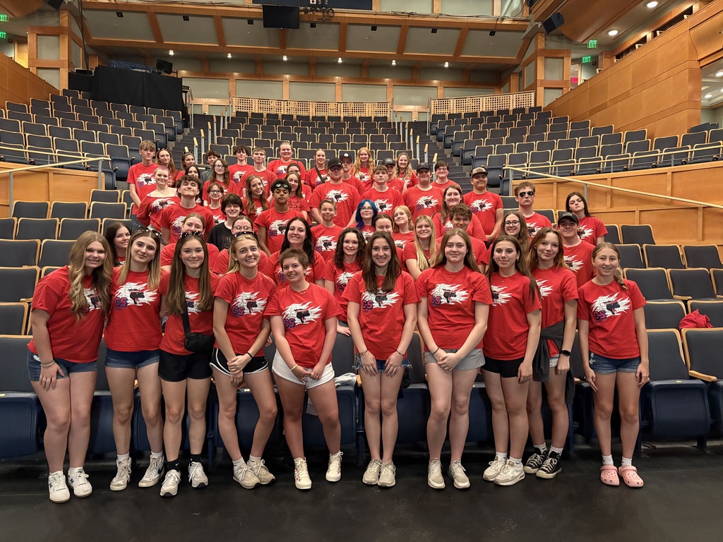 Band group photo in red shirts in auditorium