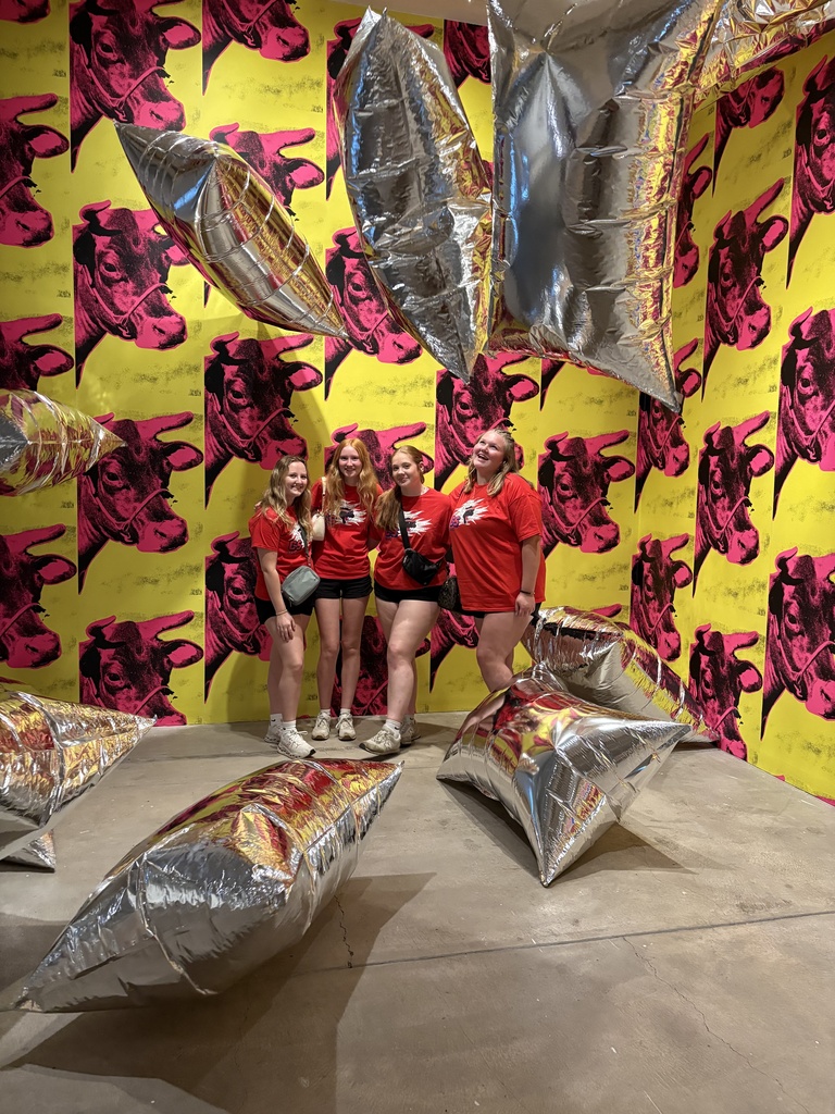 4 studnets in red shirts posing for picture