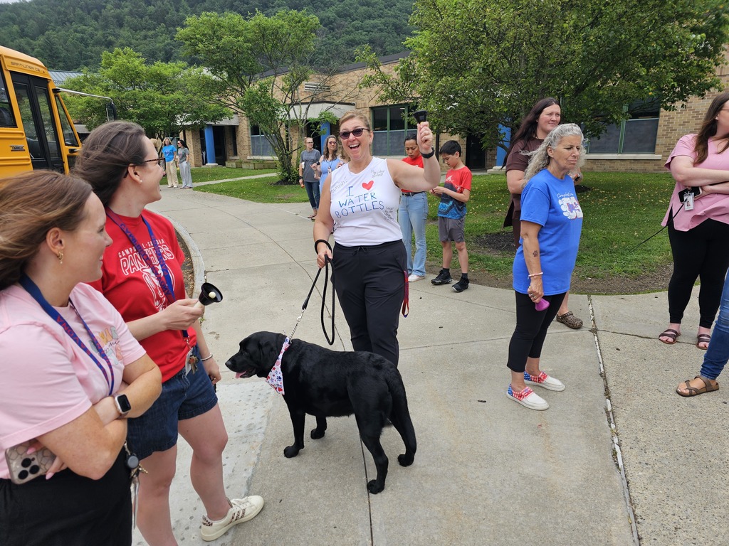Teacher with dog on leash and white t-shirt smiling