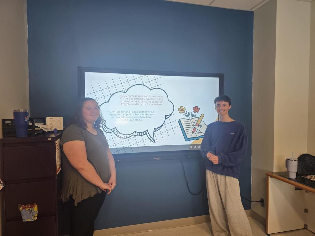 Two students standing in front of promethean board doing presentation