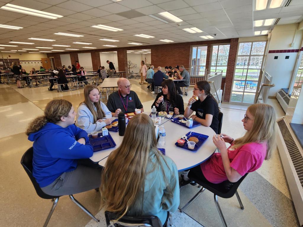 BOE members sitting with students eating lunch