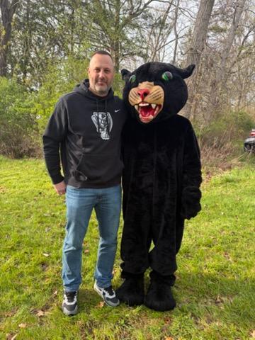 Man with school panther mascot posing for picture